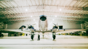 Professional holding AASSC certificate in a modern hangar.